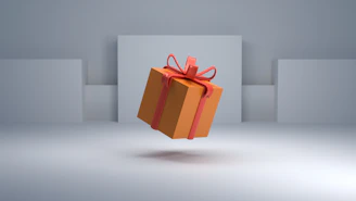 an orange gift box with a red bow