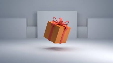 an orange gift box with a red bow