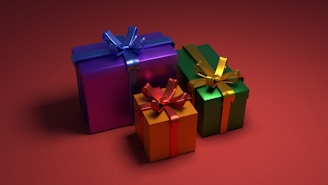 three colorful gift boxes with bows on a red background