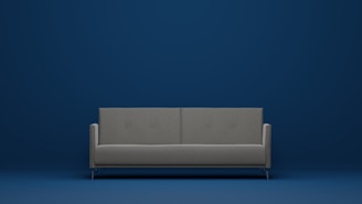 a gray couch against a blue wall