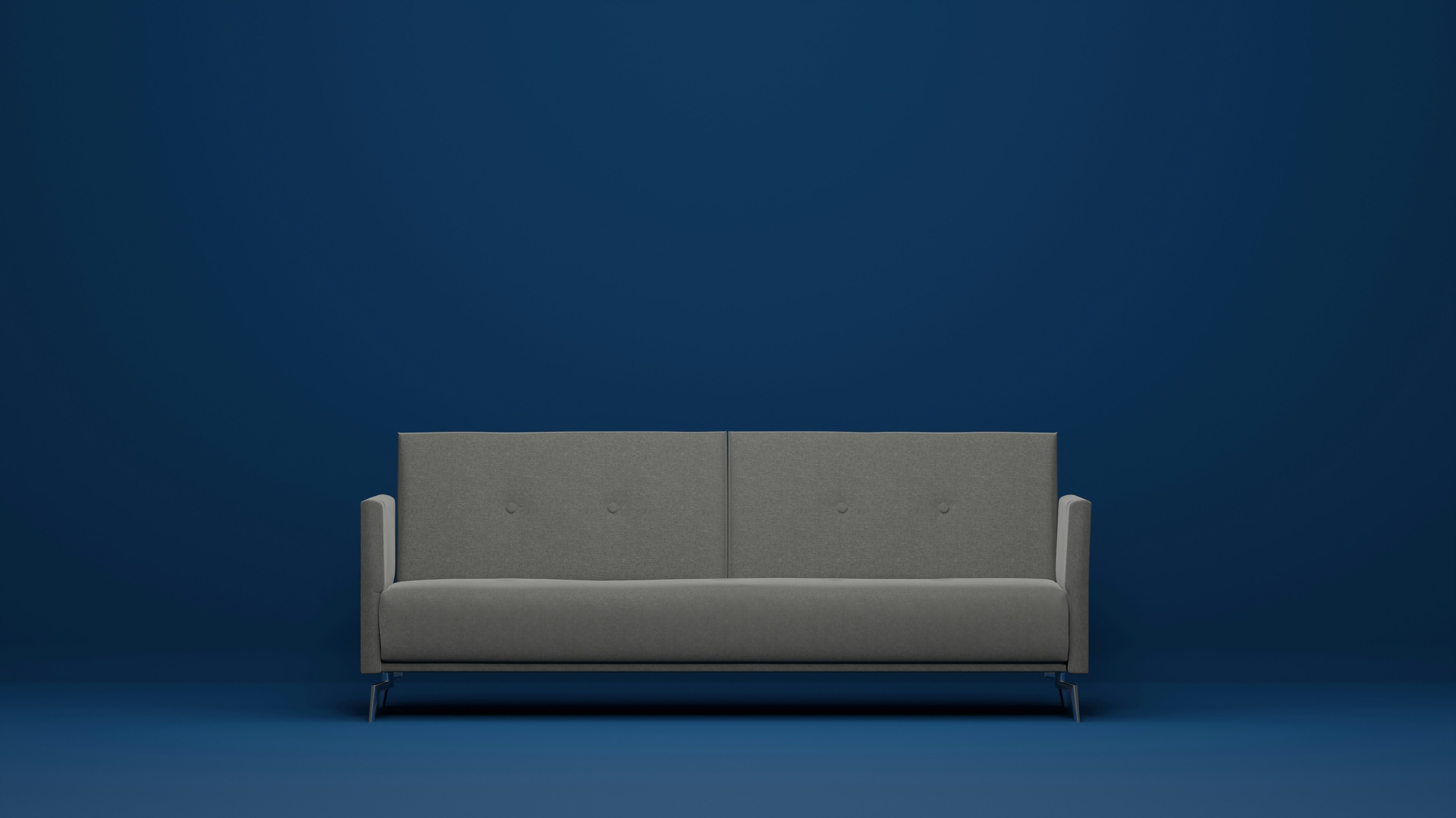 a gray couch against a blue wall
