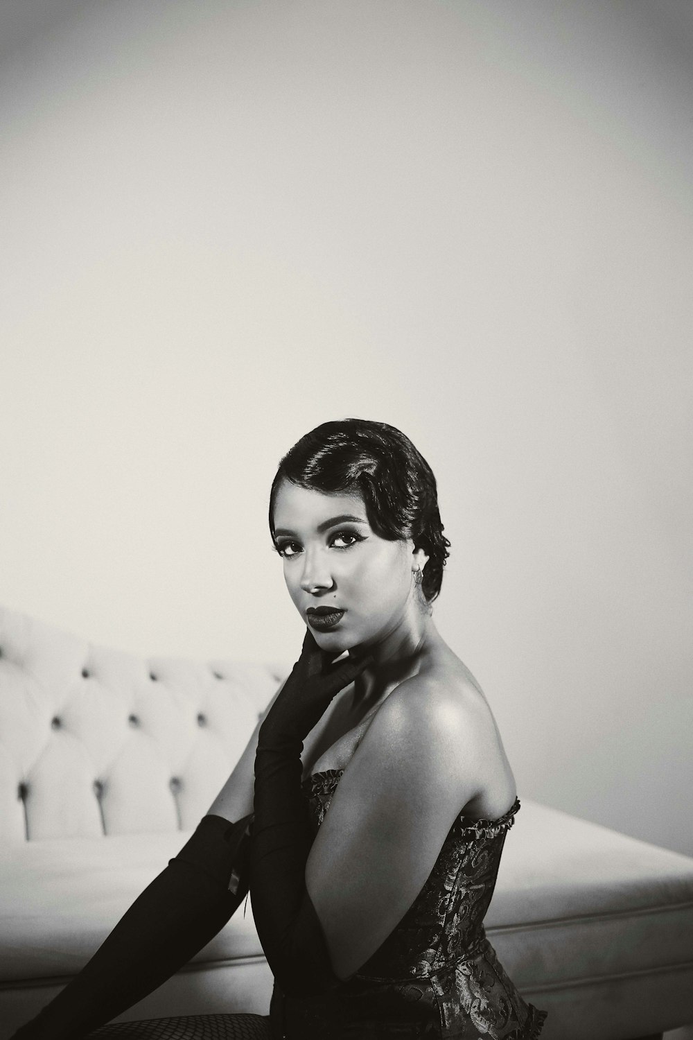 a black and white photo of a woman sitting on a couch