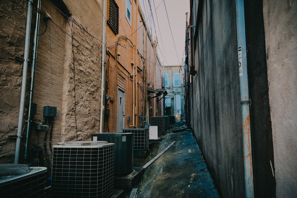 a narrow alley way with air conditioners on either side