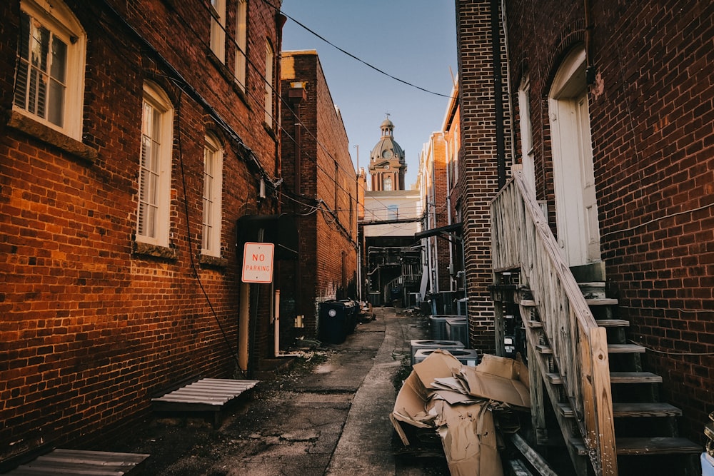 a narrow alley with a clock tower in the background