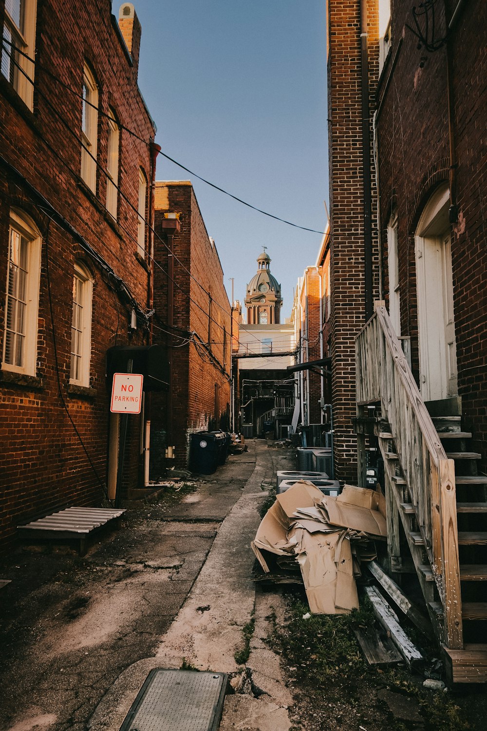 a narrow alley with a clock tower in the background