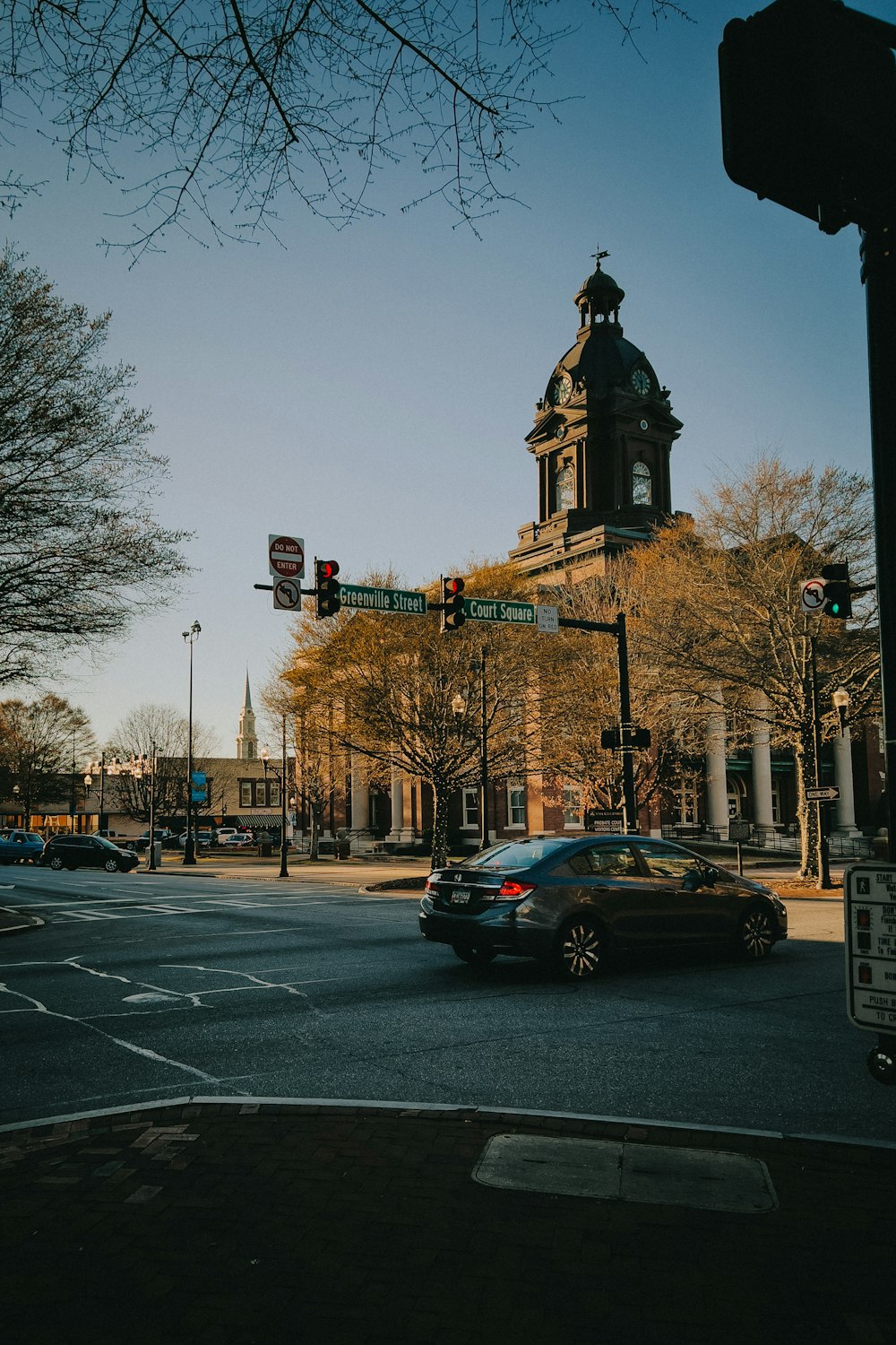 a car driving down a street next to a tall building