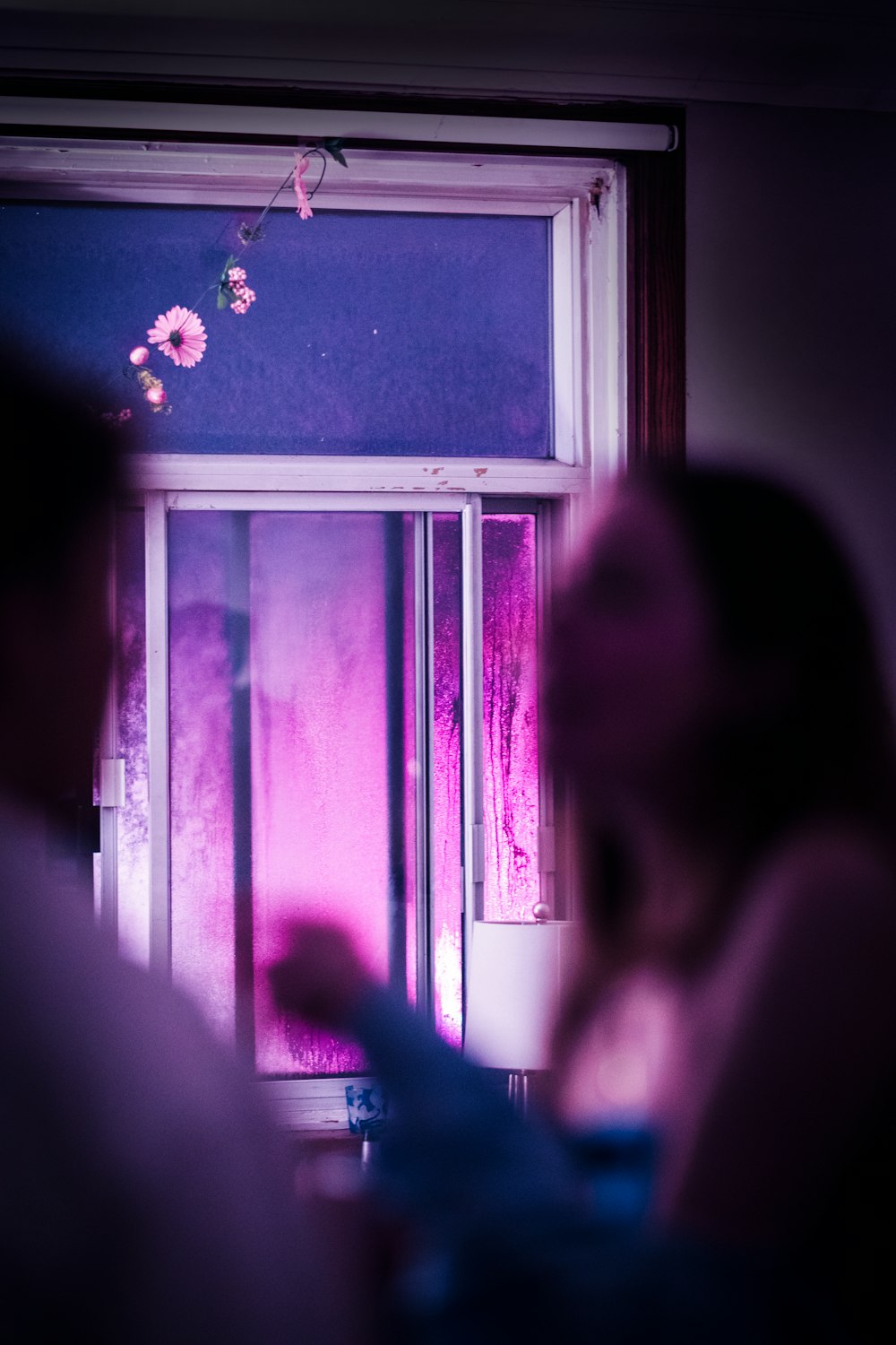 a woman standing in front of a window next to a window sill