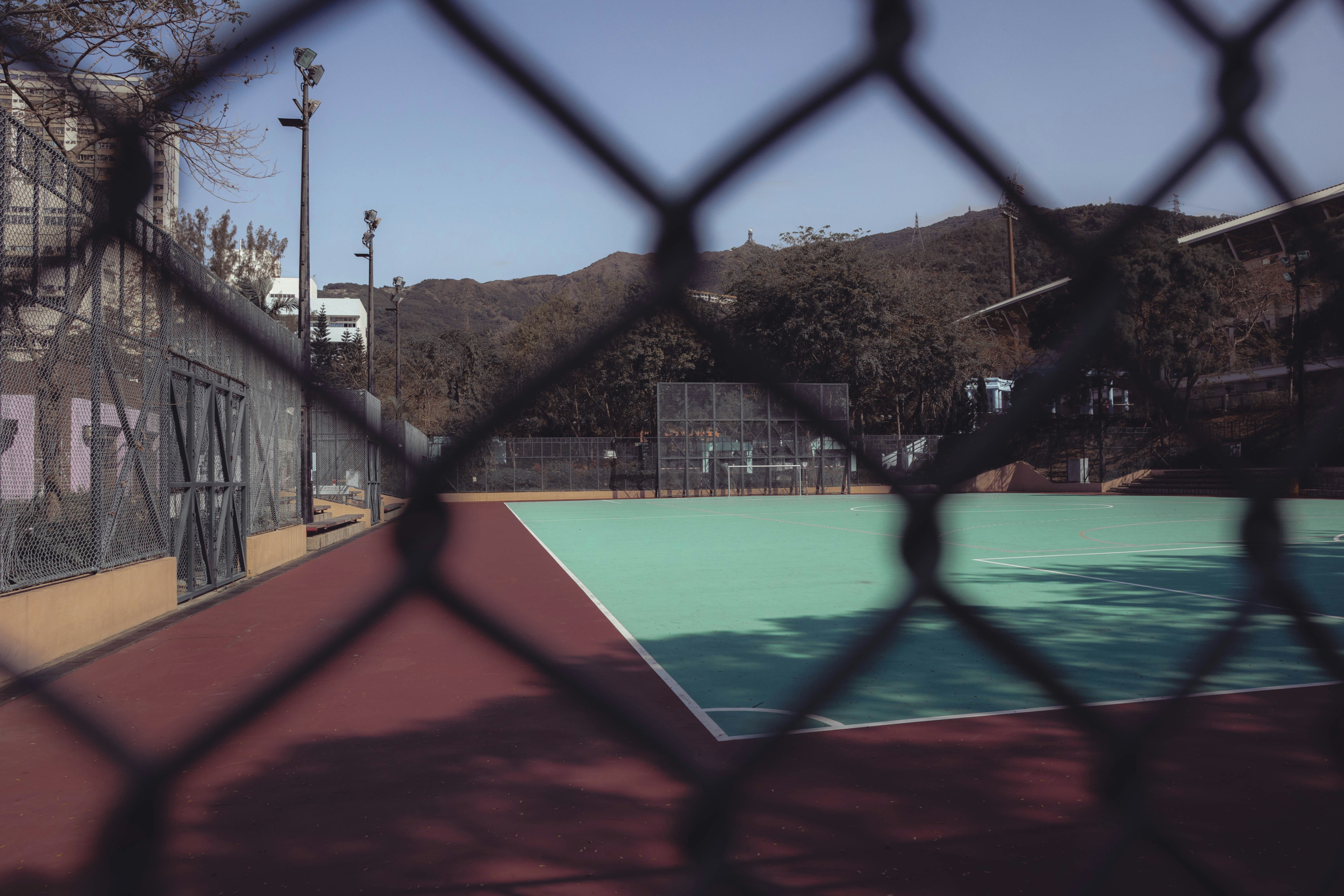 a tennis court through a chain link fence