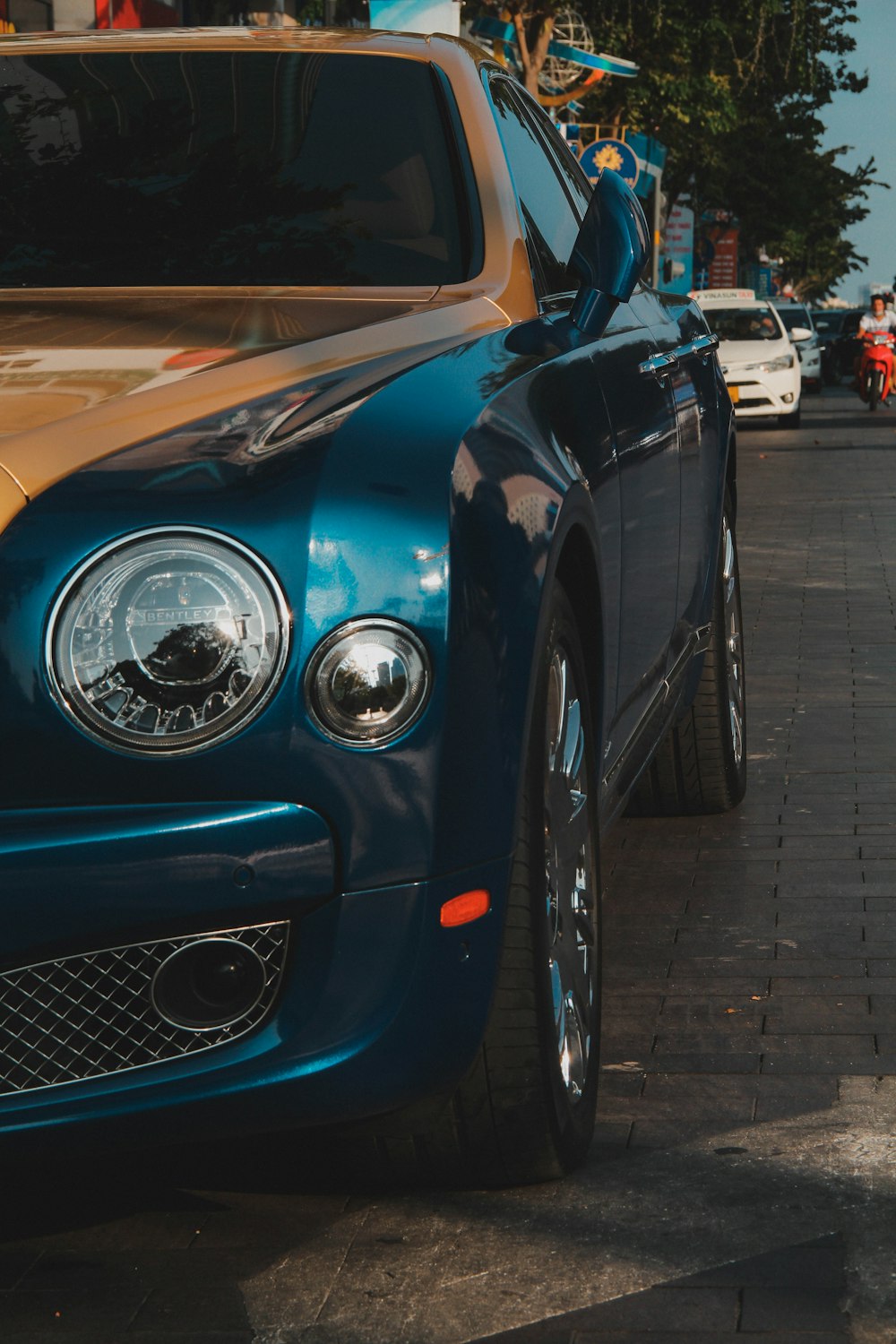 a blue bentley parked on the side of the road