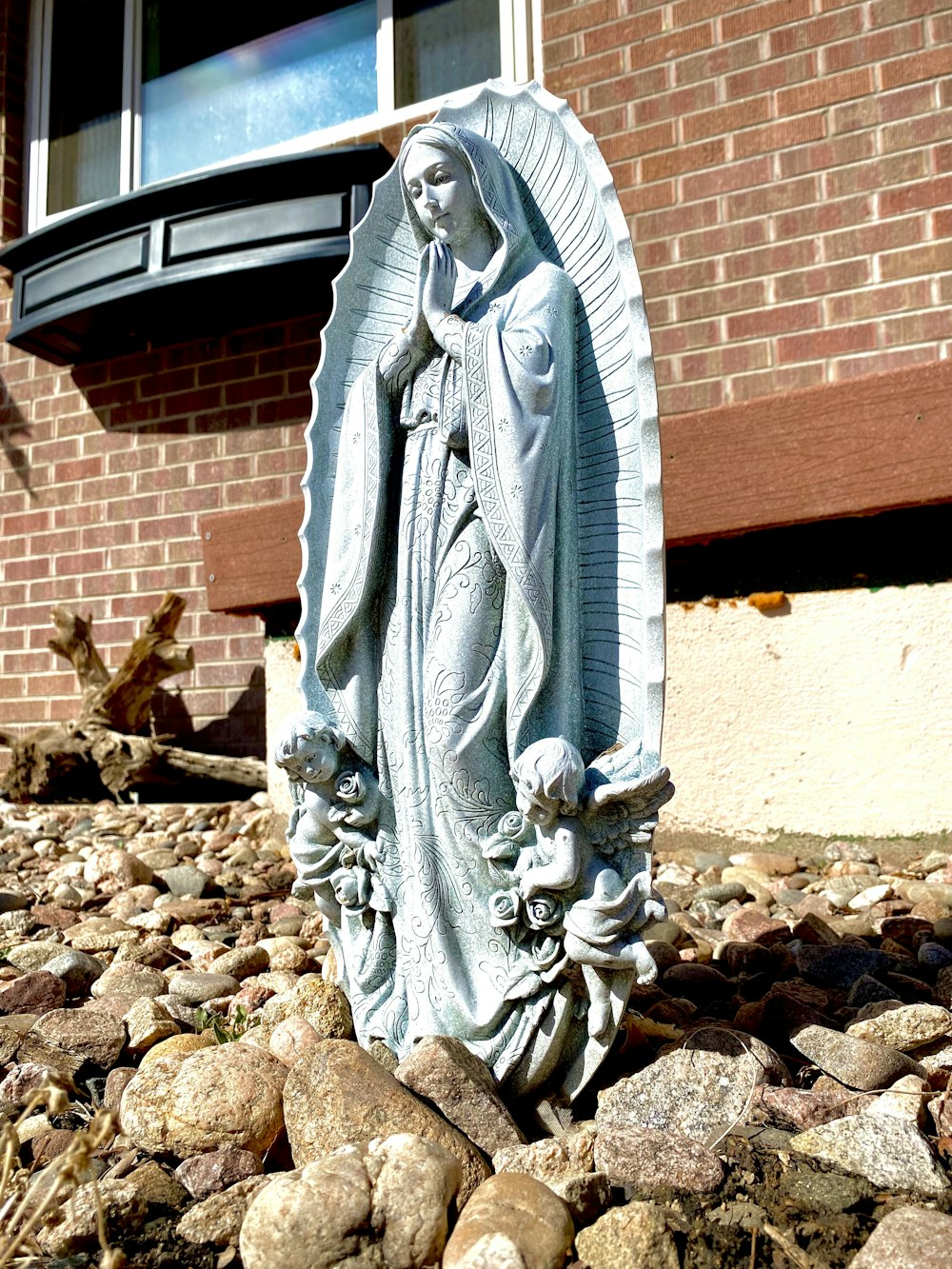 a statue of the virgin mary in front of a brick building