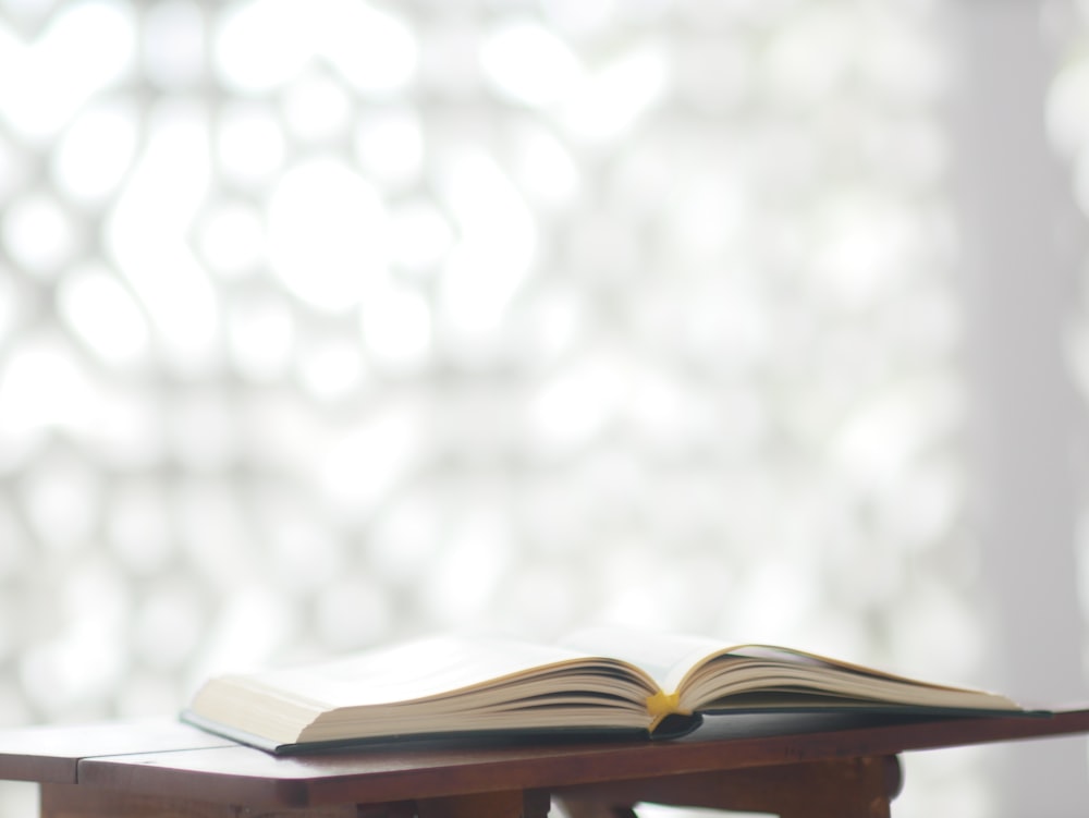 an open book sitting on top of a wooden table