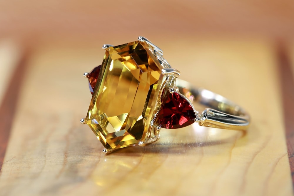 a yellow and red ring sitting on top of a wooden table