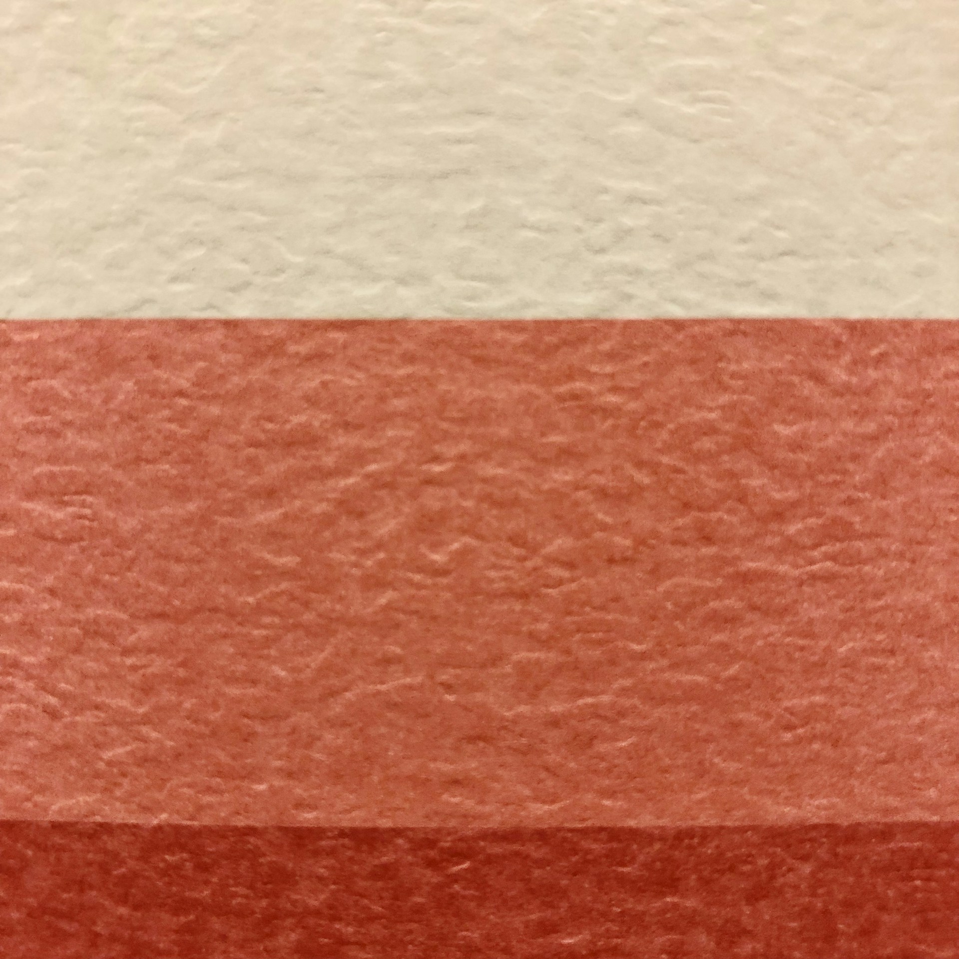 a red and white wall with a red and white stripe