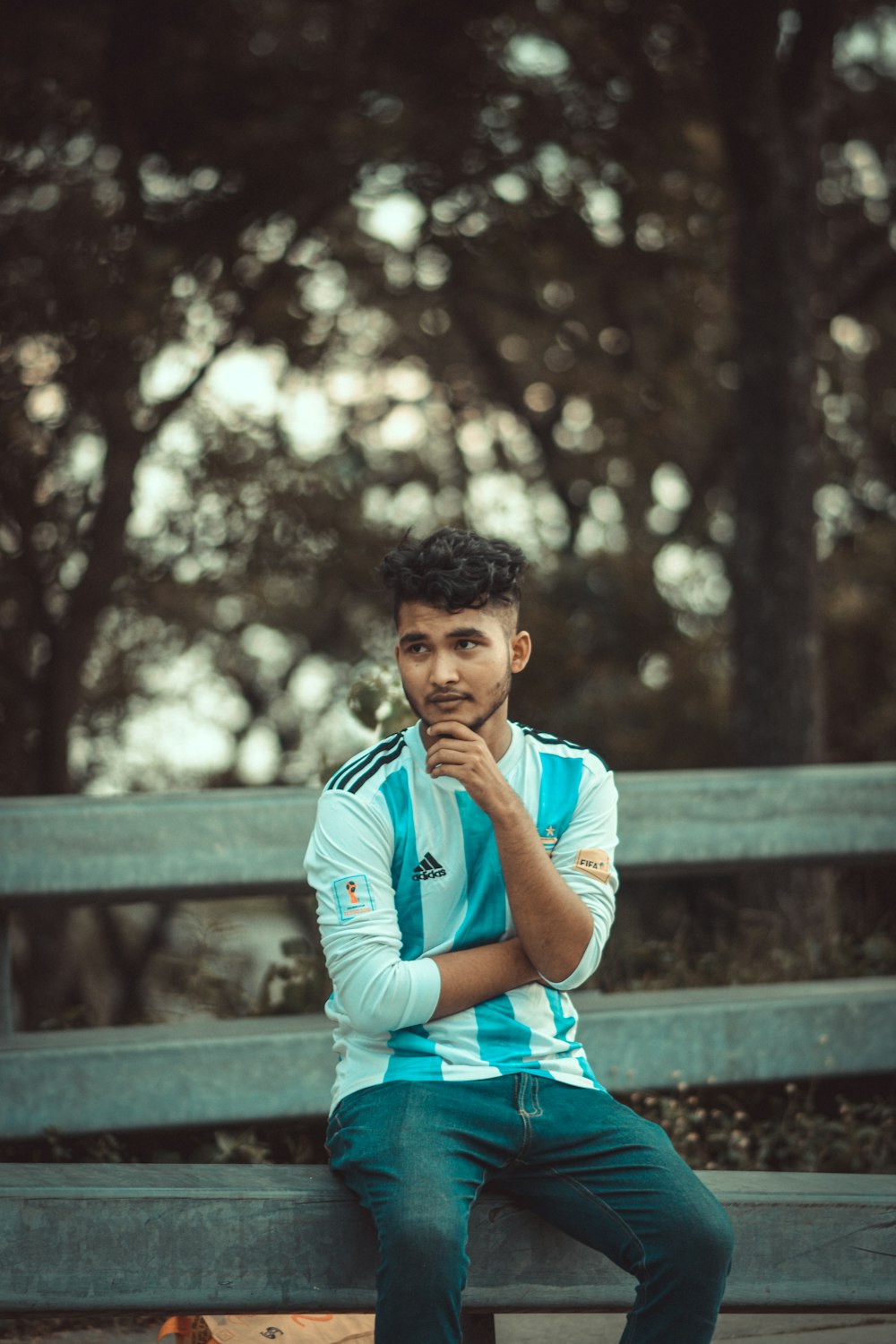 a man sitting on a bench in a park