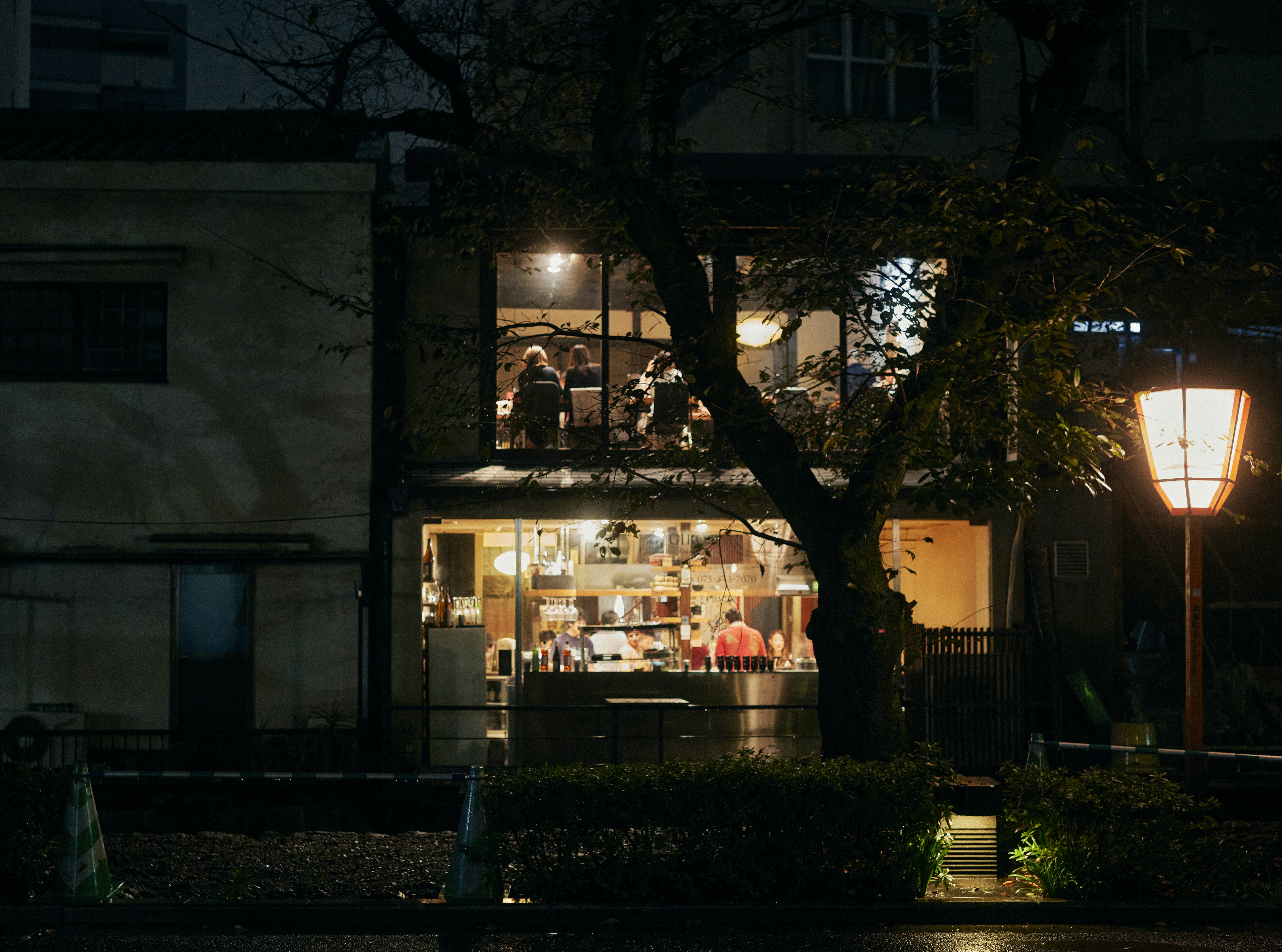 a store front at night lit up by a street lamp, 