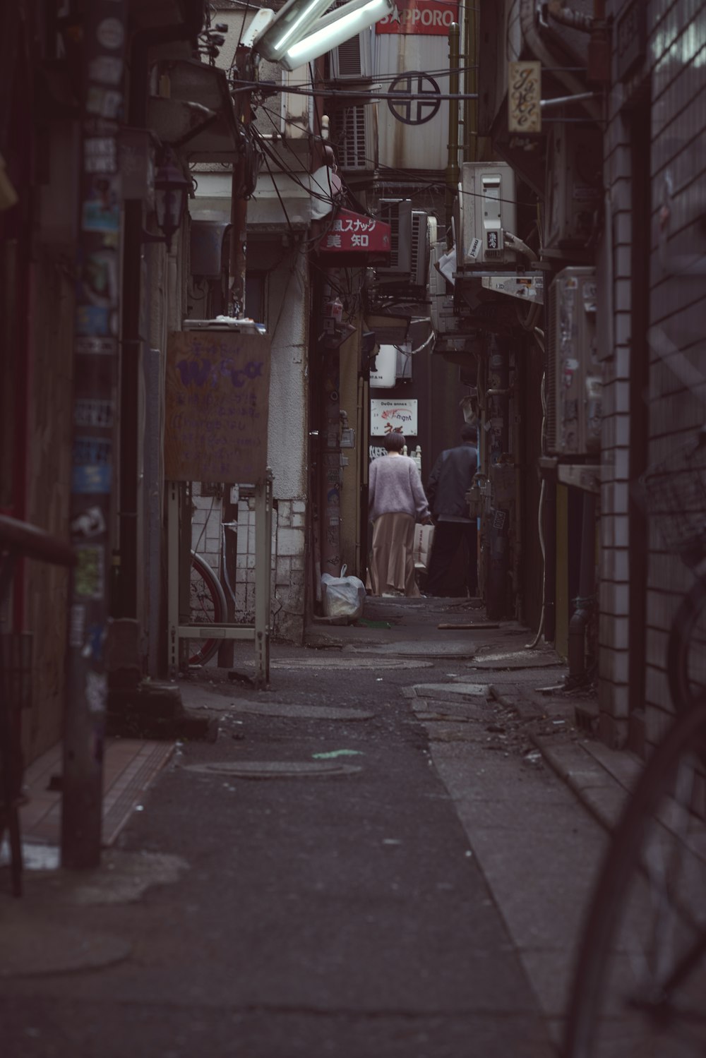 a narrow alley way with a man standing in the doorway