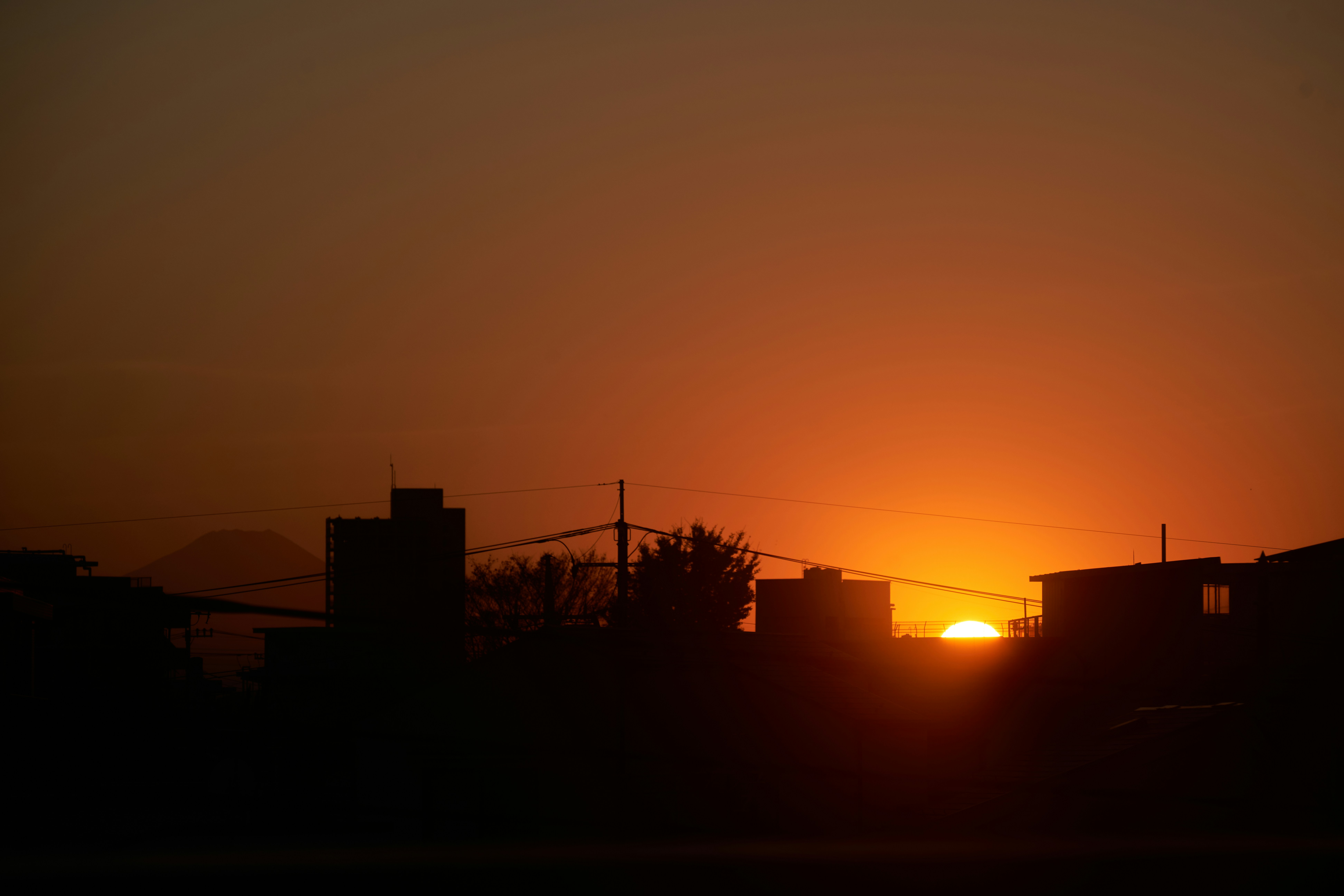 the sun is setting in the distance behind some buildings