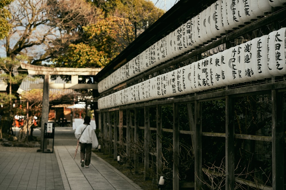 a man walking down a sidewalk next to a building