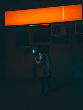 a man standing in front of a neon sign