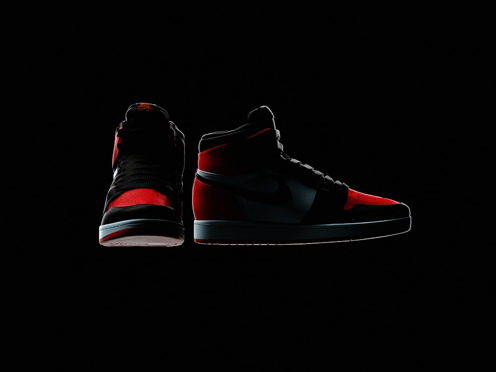 a pair of red and black sneakers on a black background