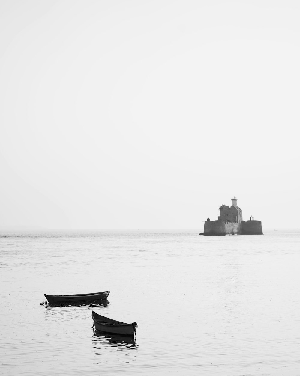 a couple of small boats floating on top of a body of water