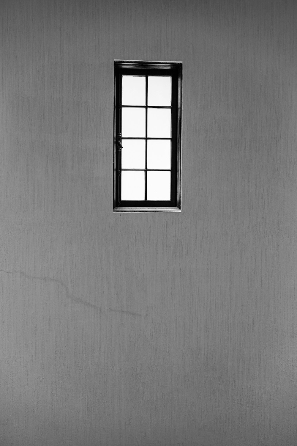 Una foto en blanco y negro de una ventana en una pared