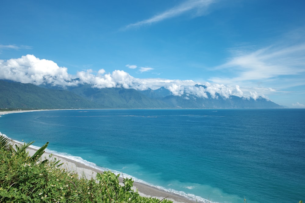 a view of the ocean and mountains from a hill