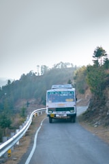A large, white charter bus driving along a scenic Northern Virginia road.