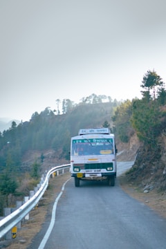 A sleek bus winding along a scenic mountain road in Brazil