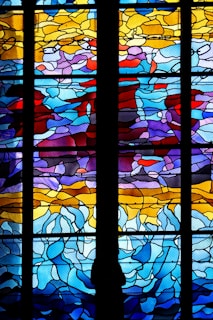 A bright and colorful window art piece showcasing abstract shapes that catch the sunlight beautifully.