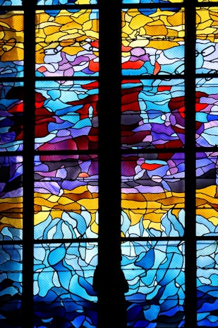 A bright and colorful window art piece showcasing abstract shapes that catch the sunlight beautifully.