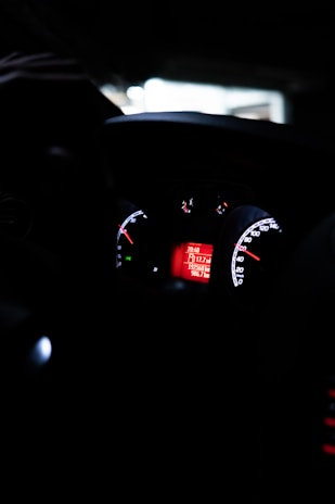 Close-up of a car dashboard with illuminated controls and digital display.