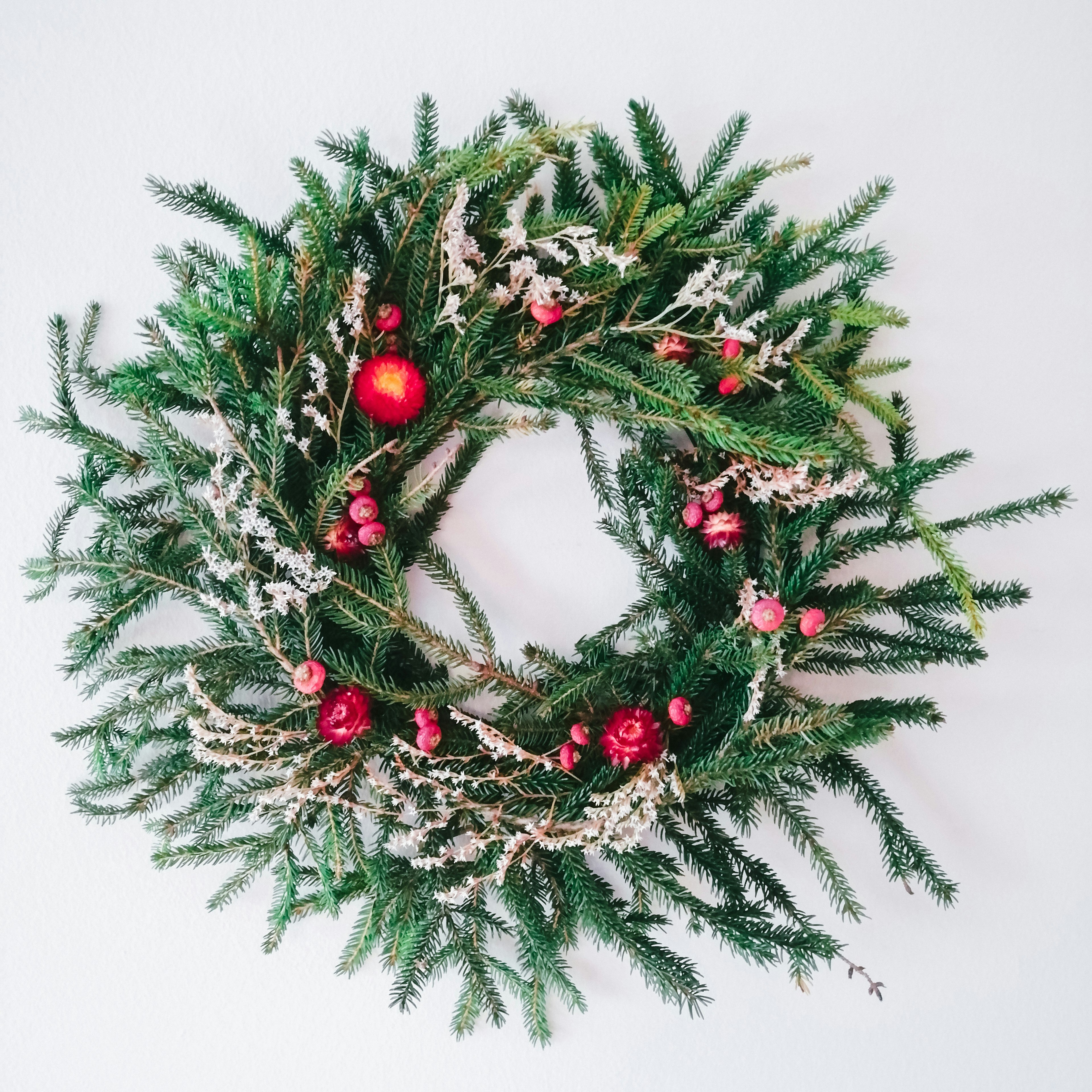 a christmas wreath with red berries and greenery