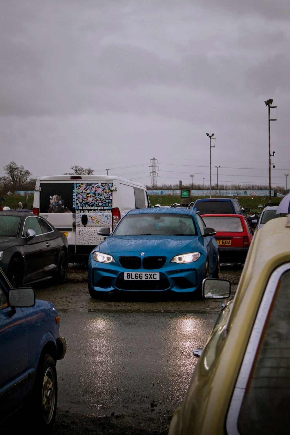 a blue car parked in a parking lot next to other cars