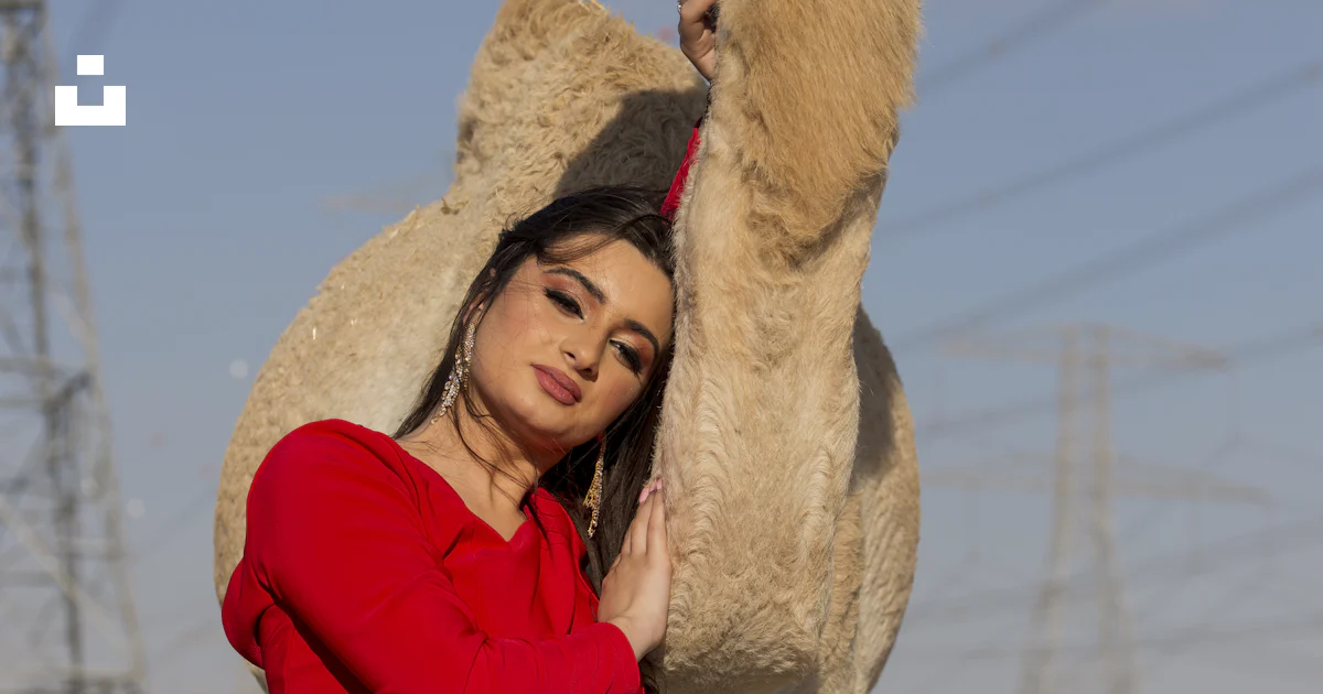 Foto Una mujer de pie junto a un camello en el desierto – Imagen Moda ...