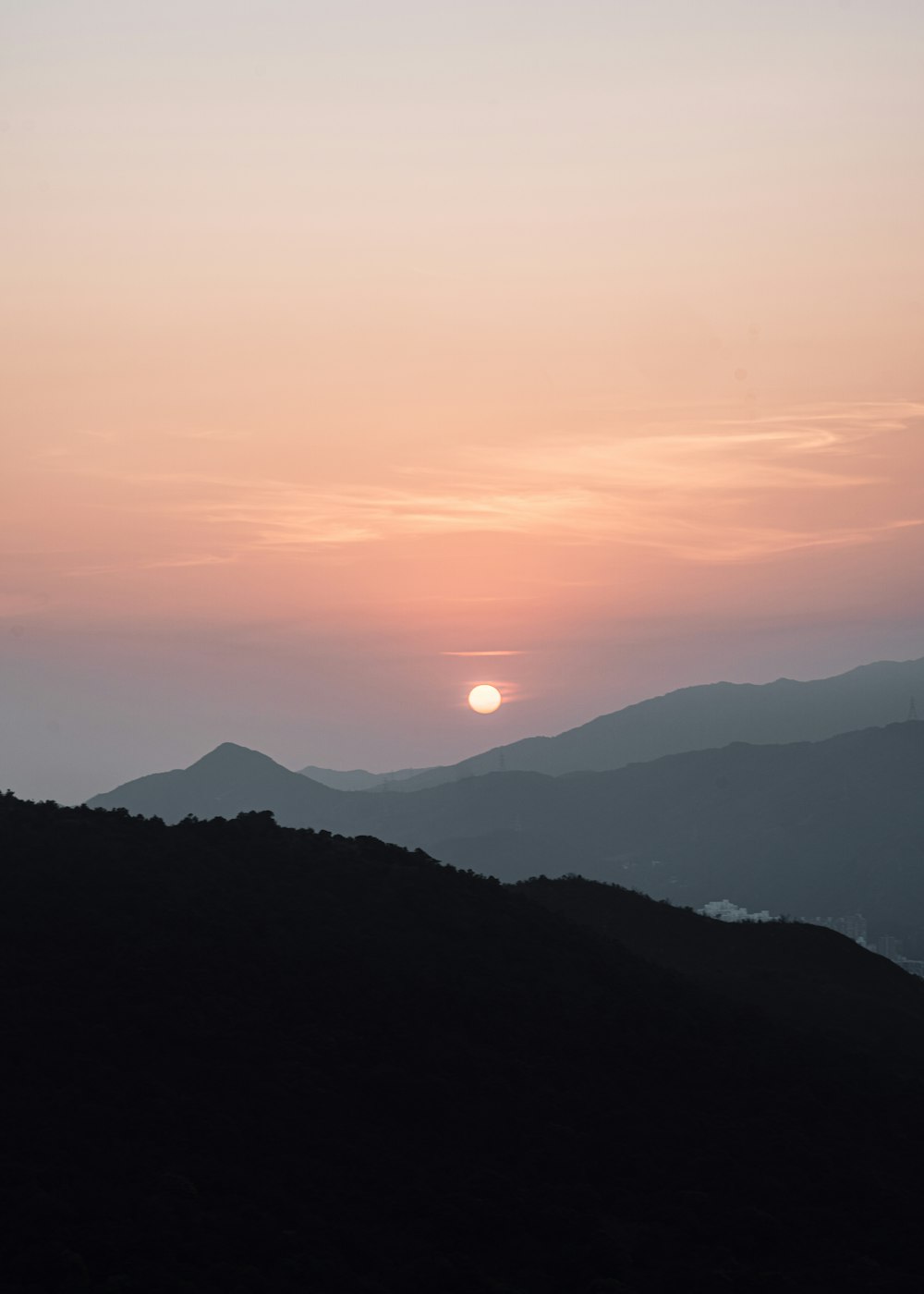 the sun is setting over a mountain range