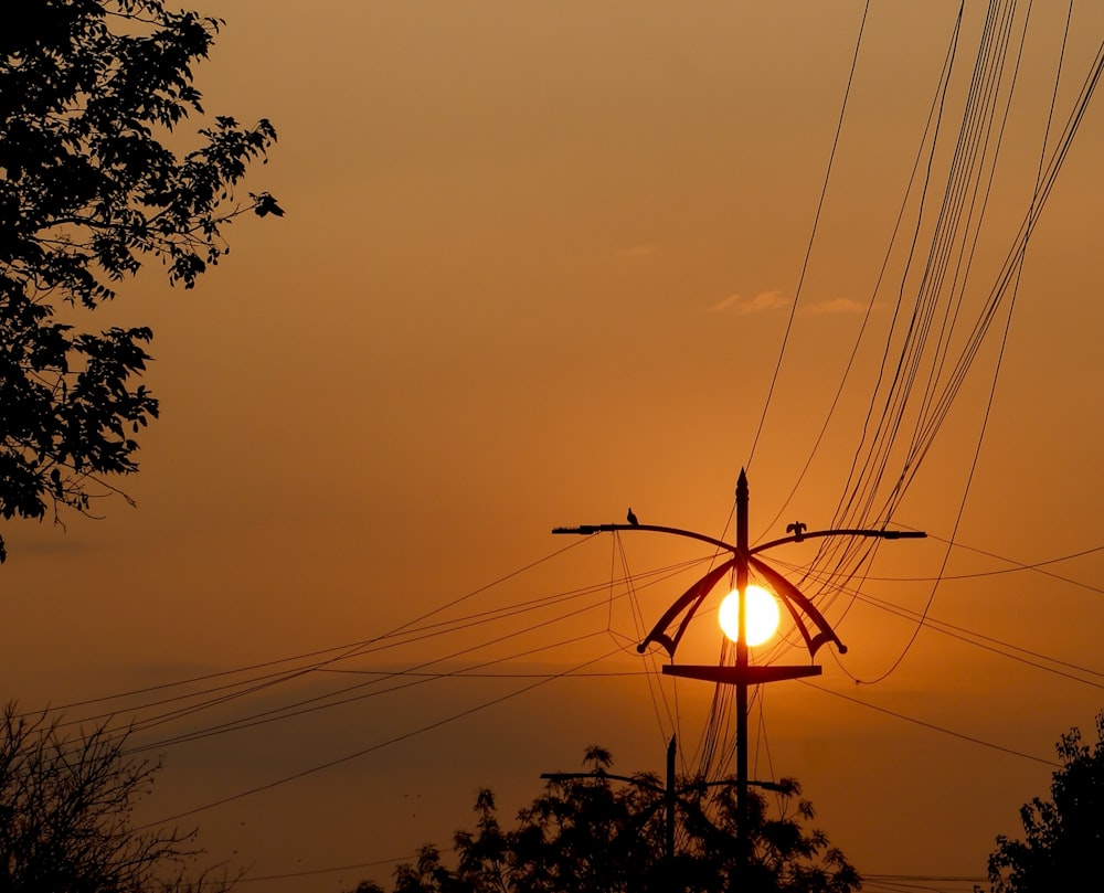 the sun is setting behind the power lines