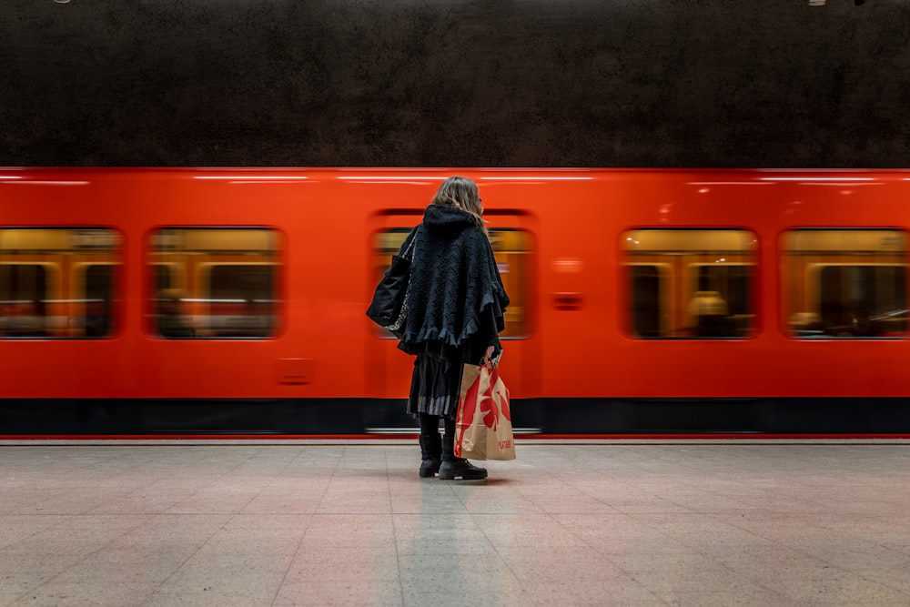 a woman standing in front of a red train