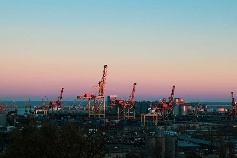 a view of a city with cranes in the foreground