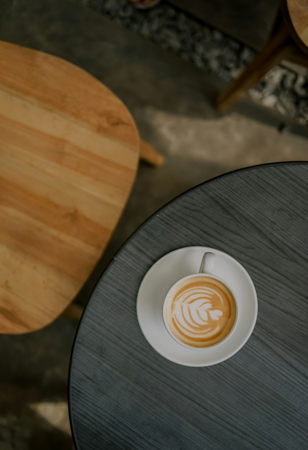 a cup of coffee sitting on top of a wooden table