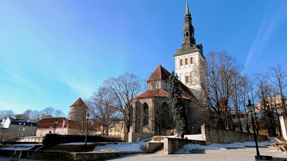 uma igreja com um campanário cercado por árvores