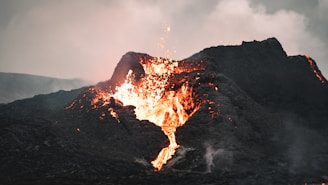 A colorful model volcano erupting with red lava flowing down.