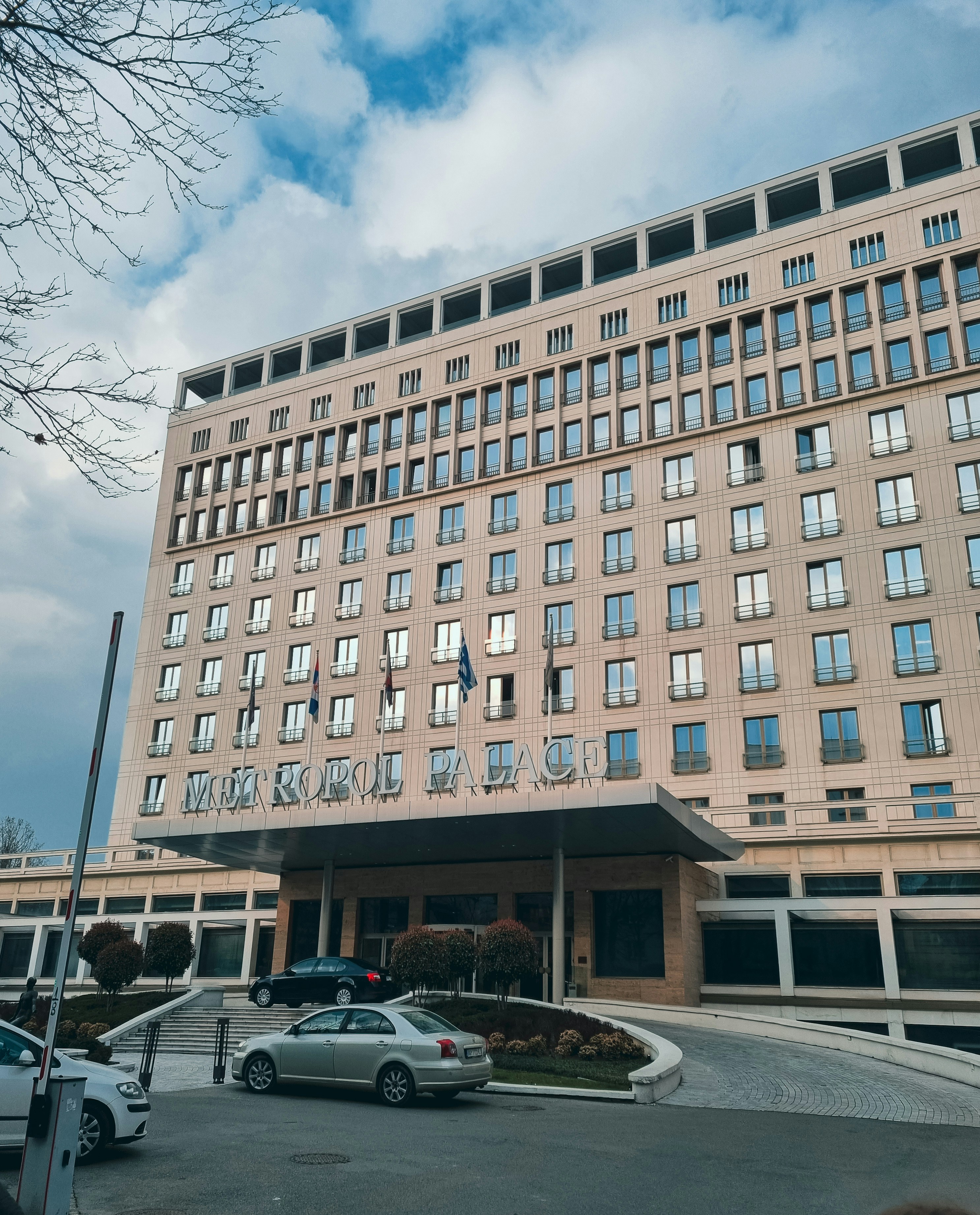 un grande edificio con molte finestre e auto parcheggiate di fronte ad esso