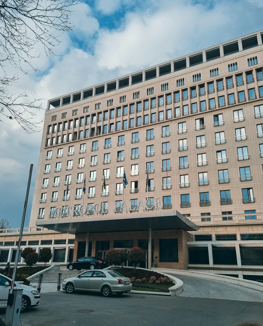 a large building with many windows and cars parked in front of it