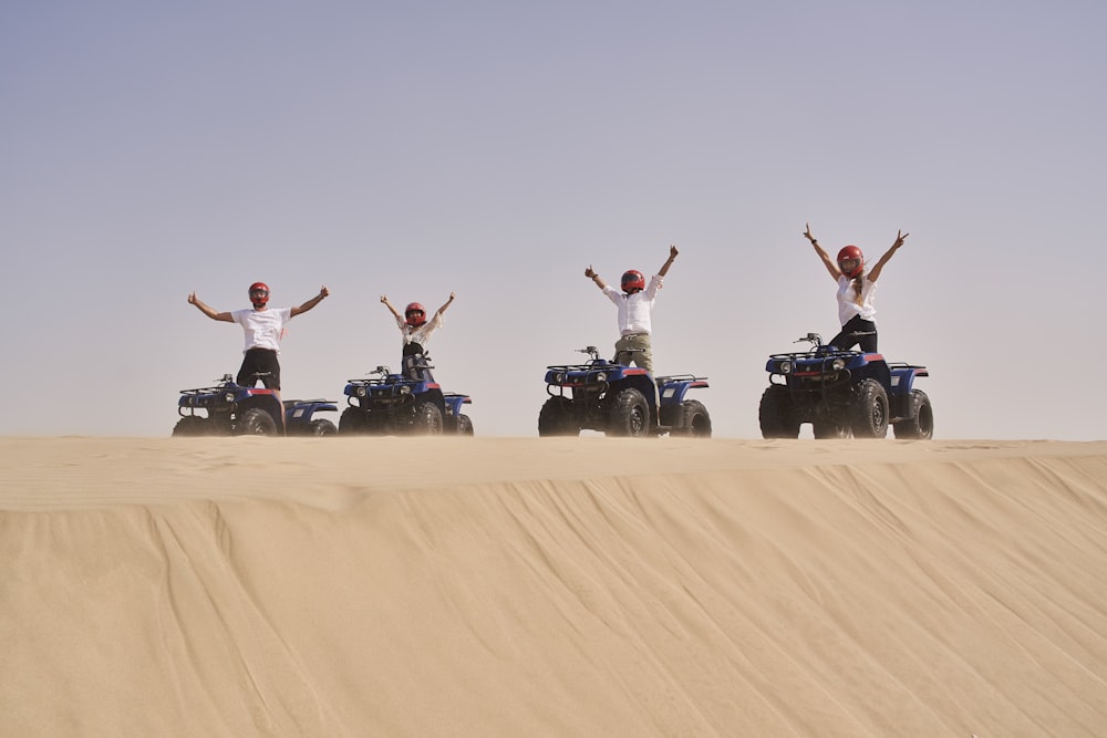 a group of people riding four wheelers in the desert