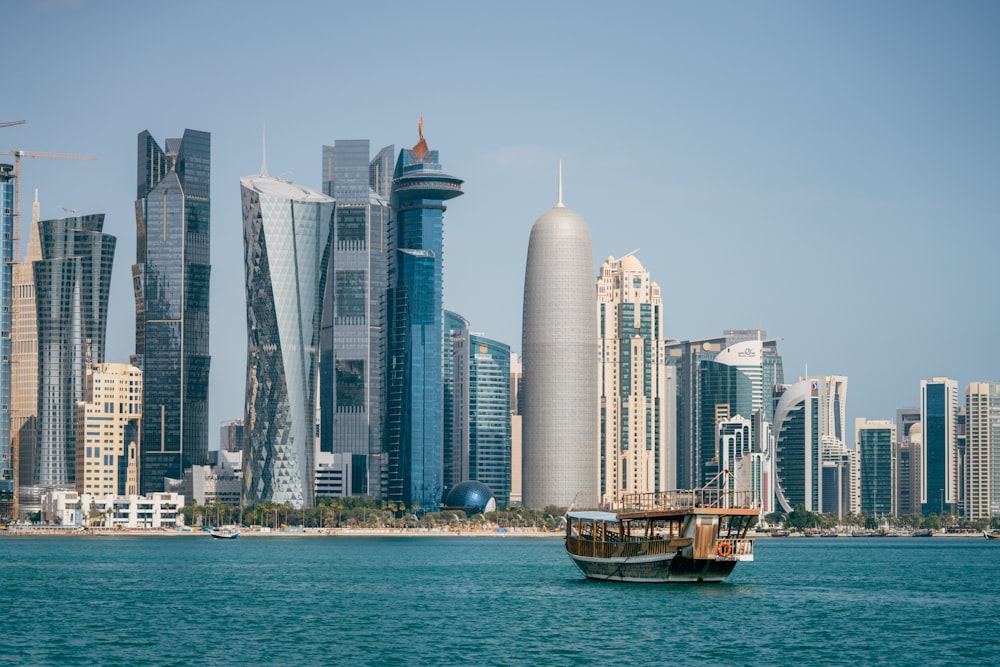 a boat in the middle of a body of water with a city in the background