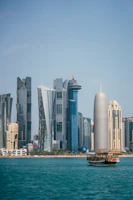 a boat in a body of water with a city in the background