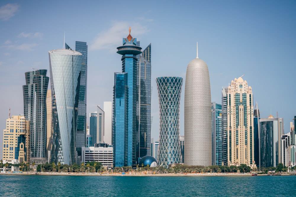 a group of tall buildings sitting next to a body of water