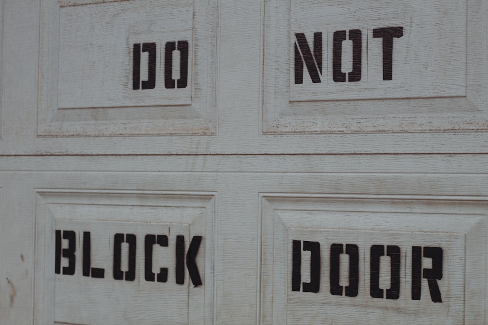 a close up of a white door with black lettering on it