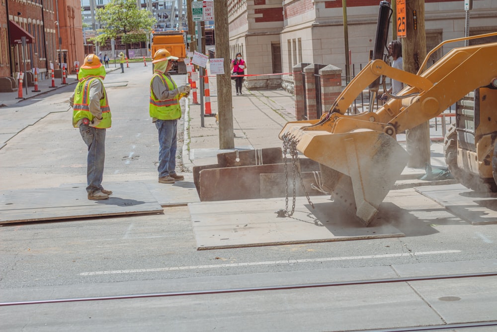 a man standing next to a bulldozer on a city street